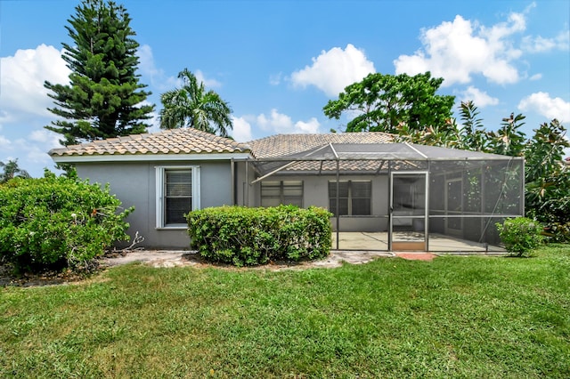 back of property with a yard and a lanai