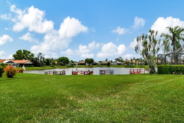 view of yard with a water view and glass enclosure