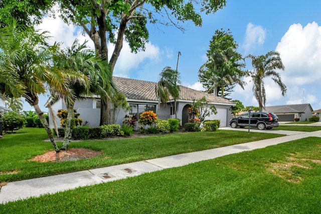 view of front of property with a front yard and a garage