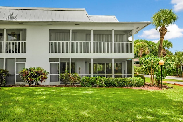 1854 SW Palm City Rd Unit 101, Stuart, FL 34994 - back of house with a lawn, a sunroom, and stucco siding