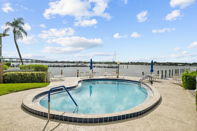 view of pool with a water view and a patio area