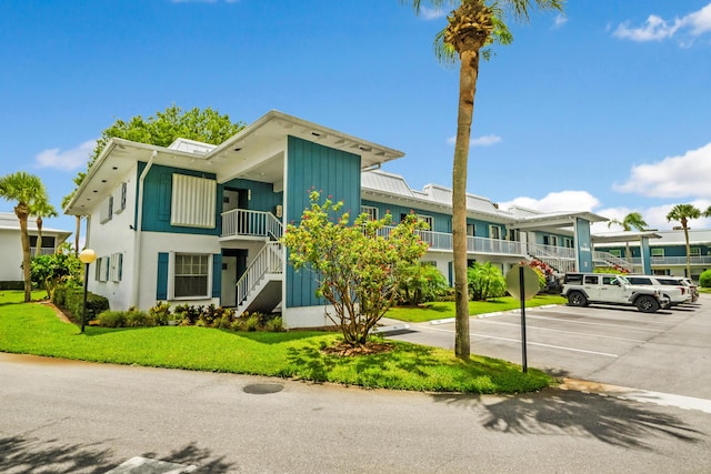 1854 SW Palm City Rd Unit 101, Stuart, FL 34994 - view of property featuring stairway and uncovered parking