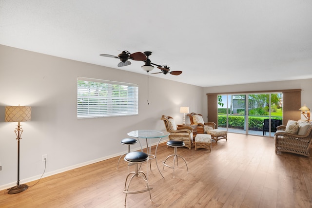 living area featuring ceiling fan, plenty of natural light, and light wood-type flooring