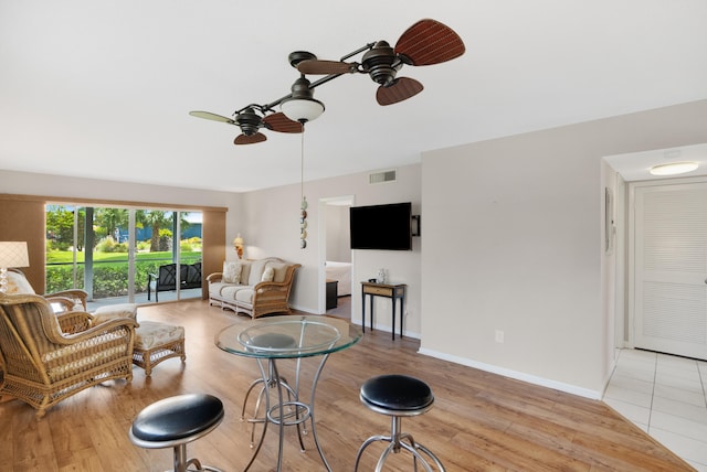 living room with light hardwood / wood-style floors and ceiling fan