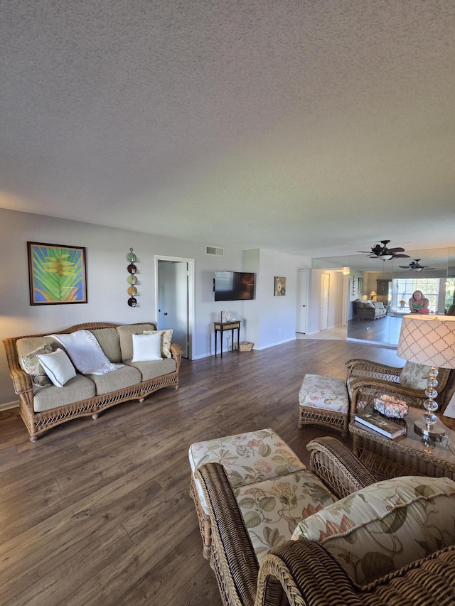 1854 SW Palm City Rd Unit 101, Stuart, FL 34994 - living area featuring a textured ceiling, wood finished floors, a ceiling fan, and baseboards