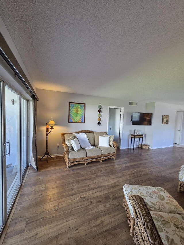 1854 SW Palm City Rd Unit 101, Stuart, FL 34994 - living room featuring a textured ceiling, wood finished floors, and baseboards
