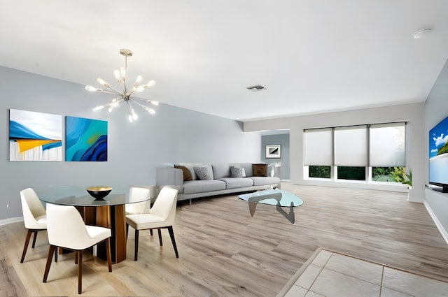 living room featuring light wood-type flooring and a notable chandelier