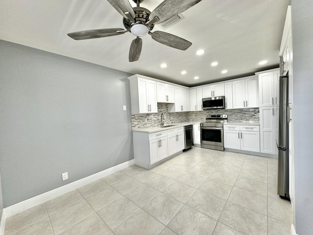 kitchen with white cabinets, backsplash, appliances with stainless steel finishes, and sink