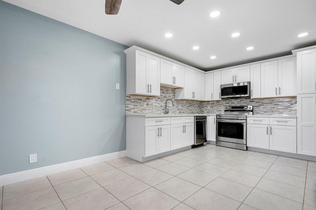 kitchen with white cabinets, appliances with stainless steel finishes, sink, and light tile patterned flooring