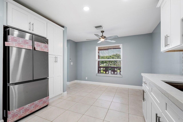 kitchen with ceiling fan, light tile patterned floors, stainless steel fridge, and white cabinetry