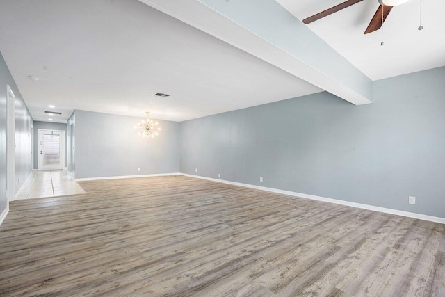 unfurnished living room with ceiling fan with notable chandelier, light hardwood / wood-style floors, and beamed ceiling