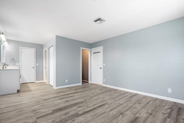 spare room with light hardwood / wood-style floors and sink