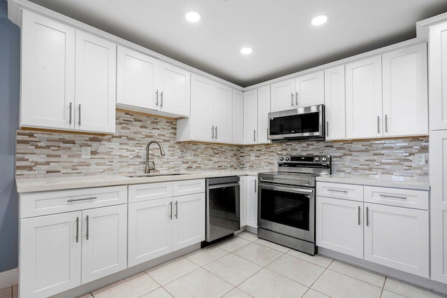 kitchen featuring sink, backsplash, light tile patterned floors, and stainless steel appliances