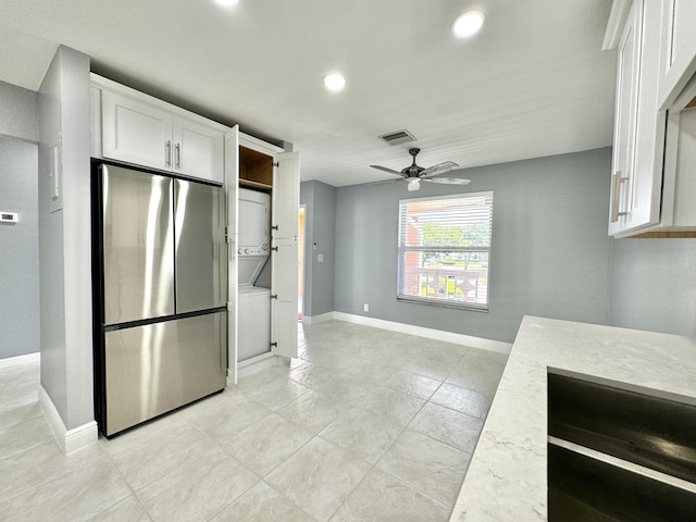 kitchen featuring ceiling fan, light stone countertops, white cabinetry, and stainless steel fridge