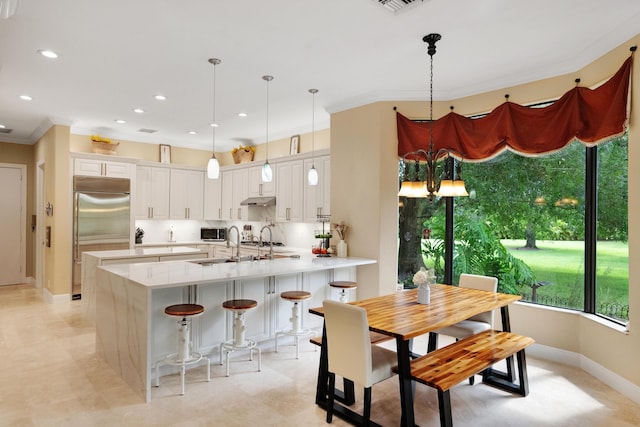 kitchen featuring pendant lighting, crown molding, appliances with stainless steel finishes, white cabinetry, and kitchen peninsula