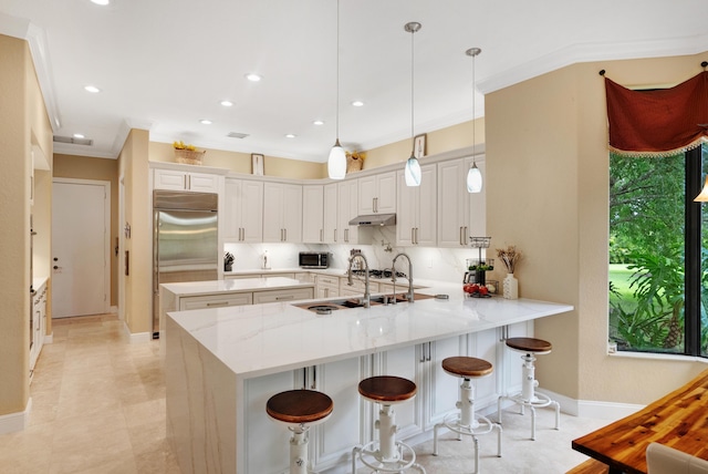 kitchen featuring sink, white cabinetry, hanging light fixtures, appliances with stainless steel finishes, and kitchen peninsula