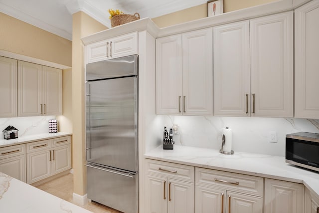 kitchen with decorative backsplash, ornamental molding, stainless steel appliances, and white cabinets