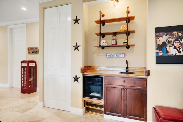 bar featuring wine cooler, butcher block countertops, ornamental molding, and sink