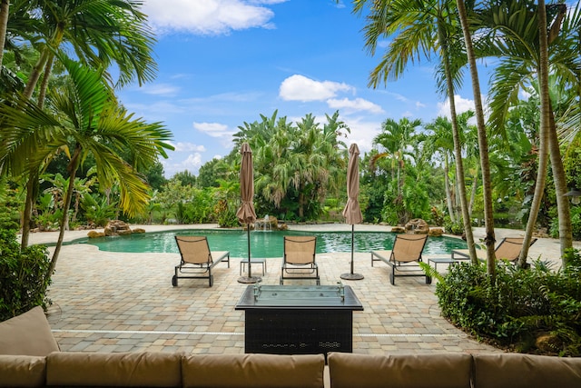 view of swimming pool with pool water feature and a patio area