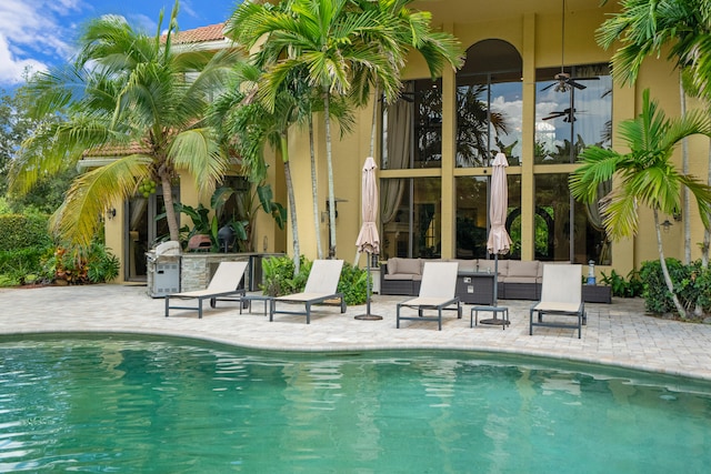 view of swimming pool featuring a patio, an outdoor hangout area, and ceiling fan