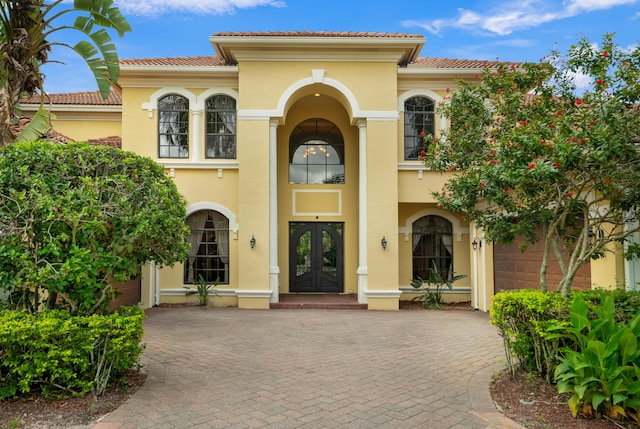 mediterranean / spanish-style home with french doors and a garage