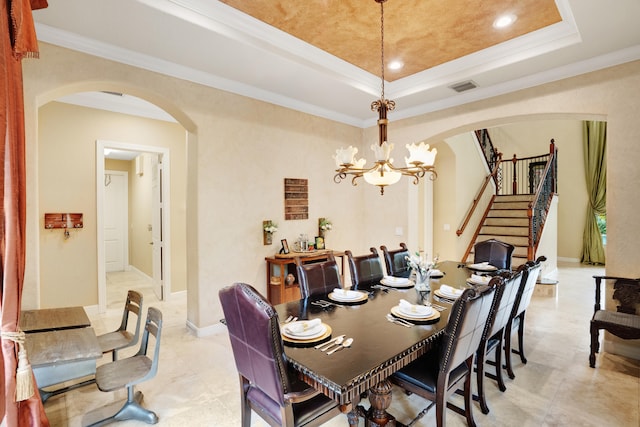 dining space featuring ornamental molding, a tray ceiling, and a notable chandelier