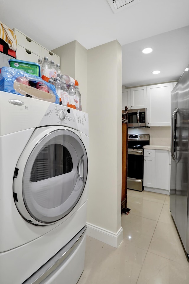 clothes washing area featuring washer / clothes dryer and light tile patterned floors