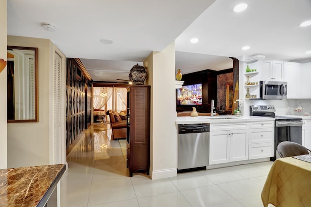 kitchen with white cabinetry, sink, stainless steel appliances, and light tile patterned flooring