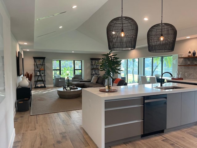 kitchen with sink, dishwashing machine, tasteful backsplash, and light hardwood / wood-style flooring