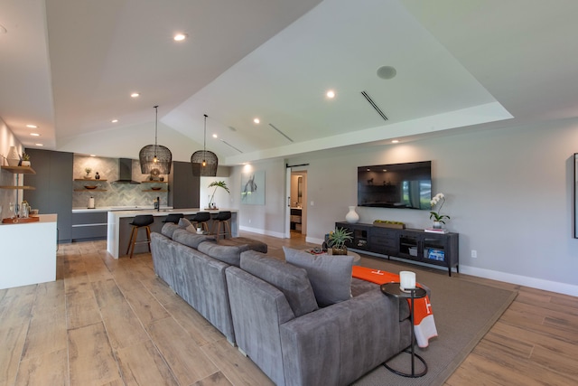 living room with light hardwood / wood-style floors and vaulted ceiling