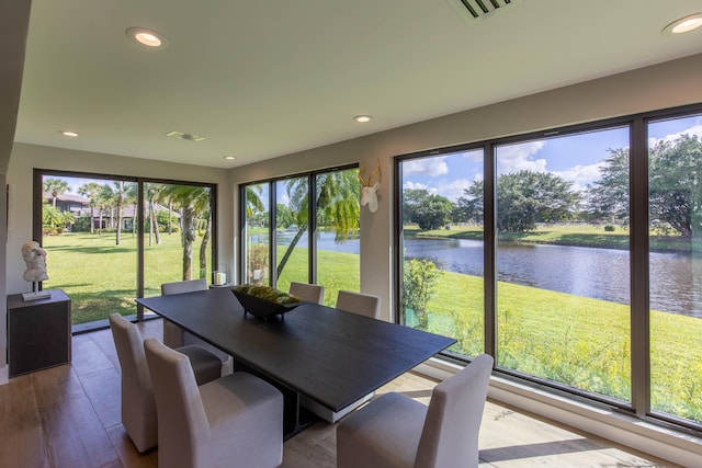 sunroom featuring a water view