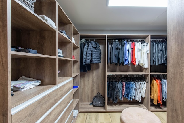 walk in closet with light hardwood / wood-style flooring