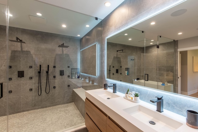 bathroom featuring a shower with door, tile walls, tasteful backsplash, and double sink vanity