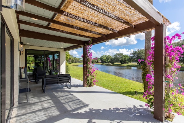 view of patio with a pergola and a water view