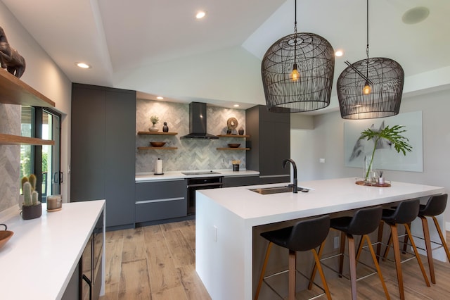 kitchen featuring black appliances, decorative backsplash, wall chimney exhaust hood, sink, and lofted ceiling