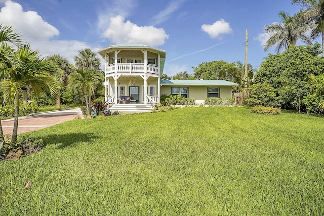 view of front of house with a balcony, a porch, and a front lawn