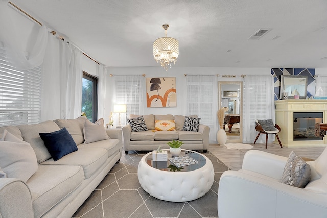 living room with an inviting chandelier and a textured ceiling