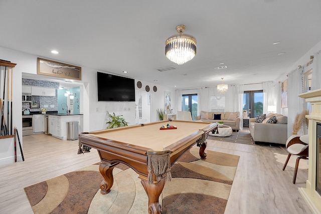 playroom featuring sink, pool table, light hardwood / wood-style flooring, and a chandelier