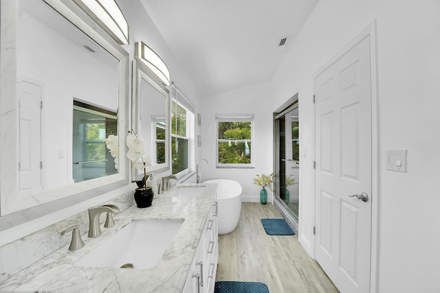 bathroom featuring a bathing tub, lofted ceiling, hardwood / wood-style floors, and vanity