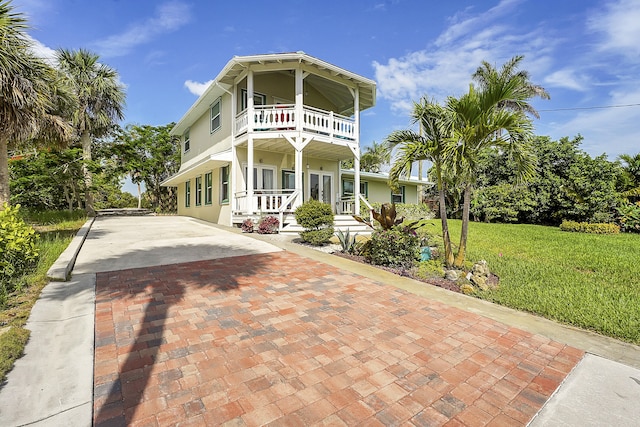 view of front of property featuring a front yard and a balcony