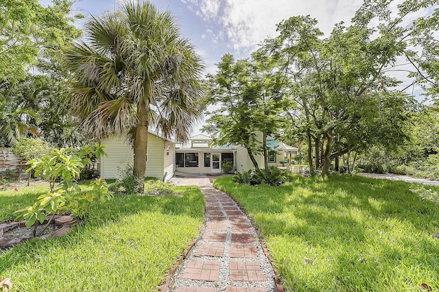 view of front facade featuring a sunroom and a front lawn