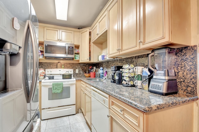 kitchen with stone counters, appliances with stainless steel finishes, light tile patterned floors, and light brown cabinets