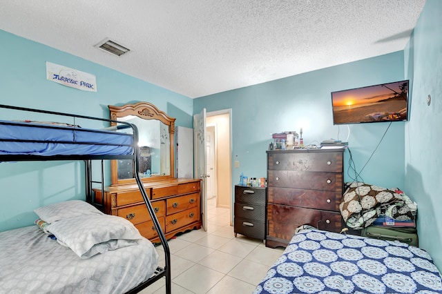 bedroom featuring light tile patterned flooring and a textured ceiling