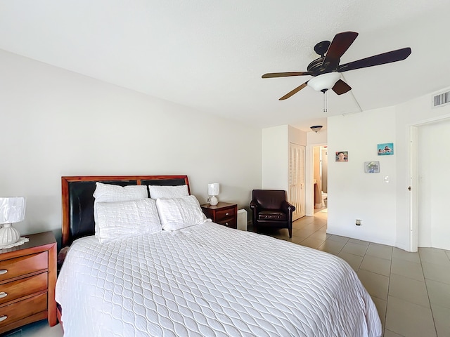 tiled bedroom with a textured ceiling and a closet