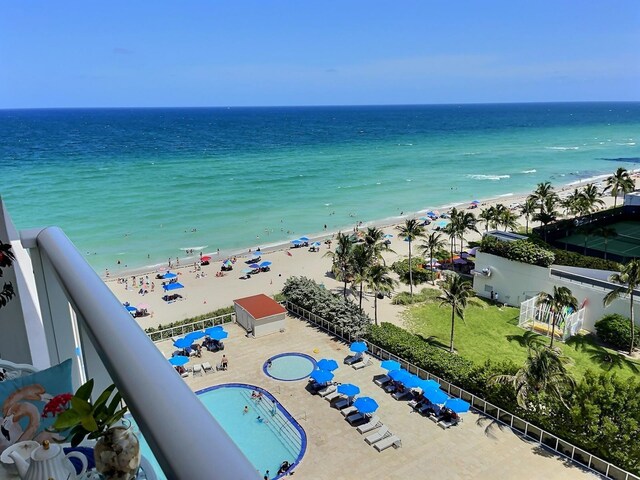 drone / aerial view with a water view and a beach view