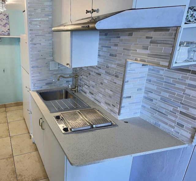 kitchen with white cabinetry, light tile patterned flooring, decorative backsplash, sink, and light stone countertops