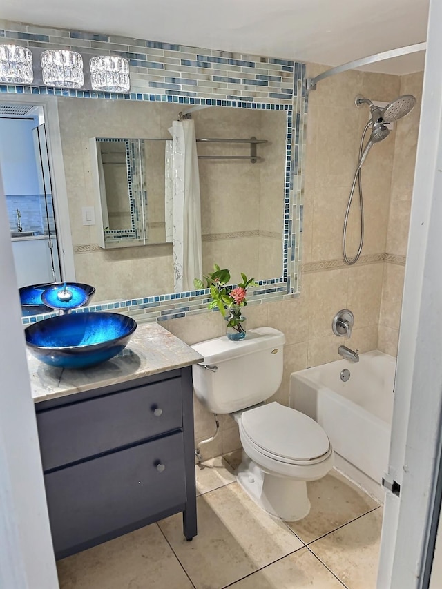 full bathroom with tile walls, tile patterned flooring, shower / bathtub combination with curtain, toilet, and vanity