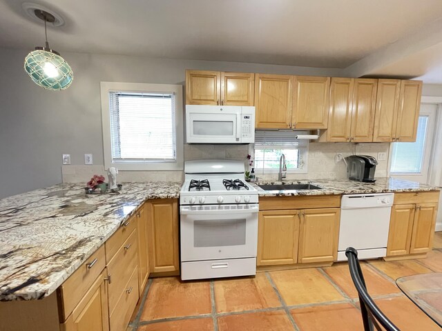 kitchen featuring light stone counters, light brown cabinets, white appliances, a sink, and backsplash