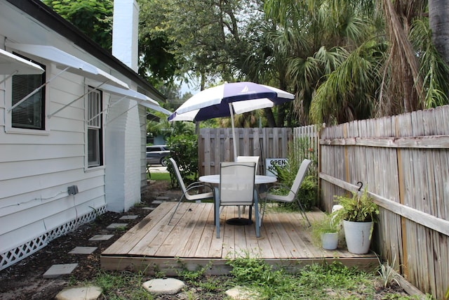 wooden deck featuring outdoor dining space and a fenced backyard