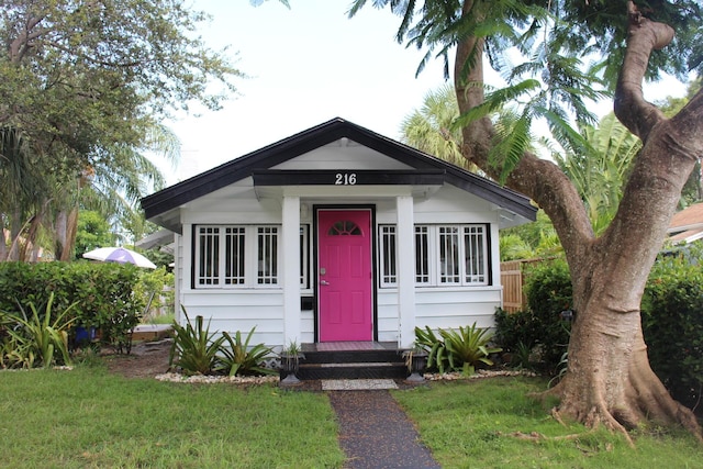 bungalow-style home with a front lawn